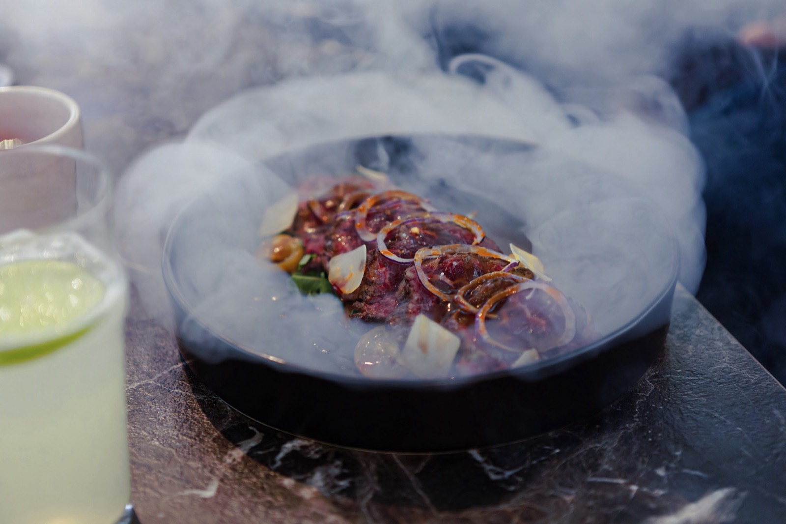 La table, à gauche — filet de bœuf grillé sous cloche